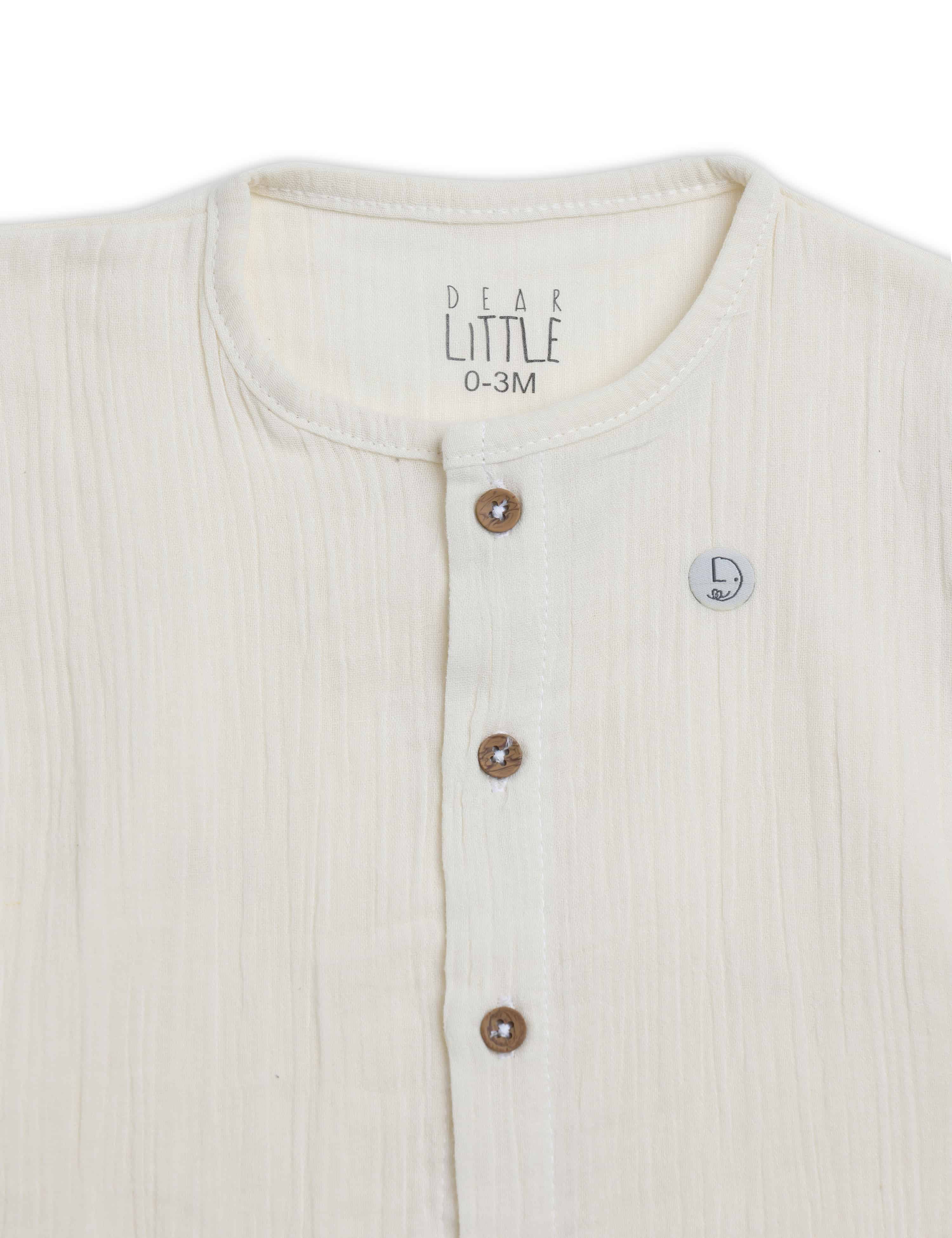Close-up of a baby outfit with buttons and 'Dear Little' branding on a white background