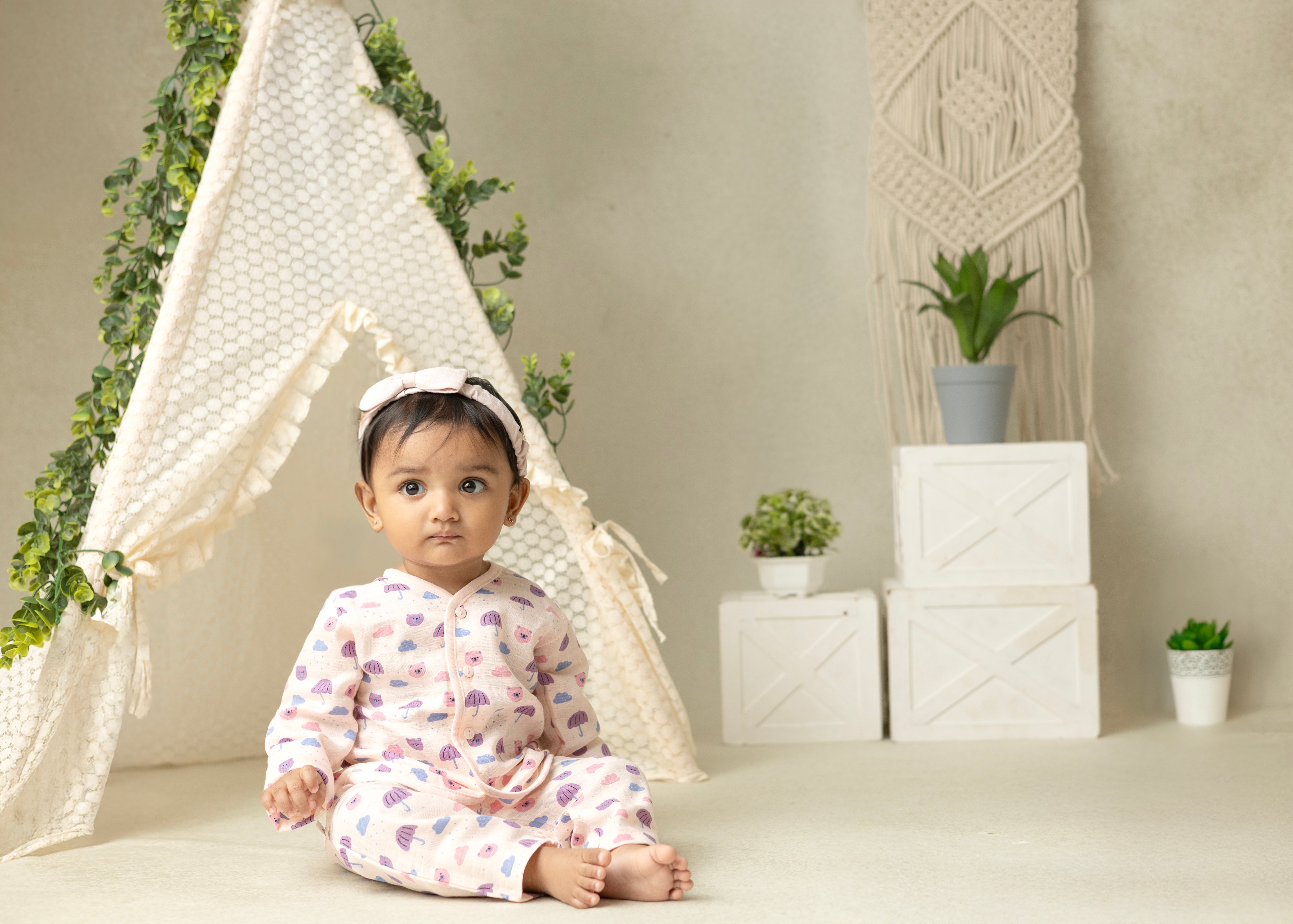 A baby wearing a peach-colored muslin full sleeve jhabla and pant set.