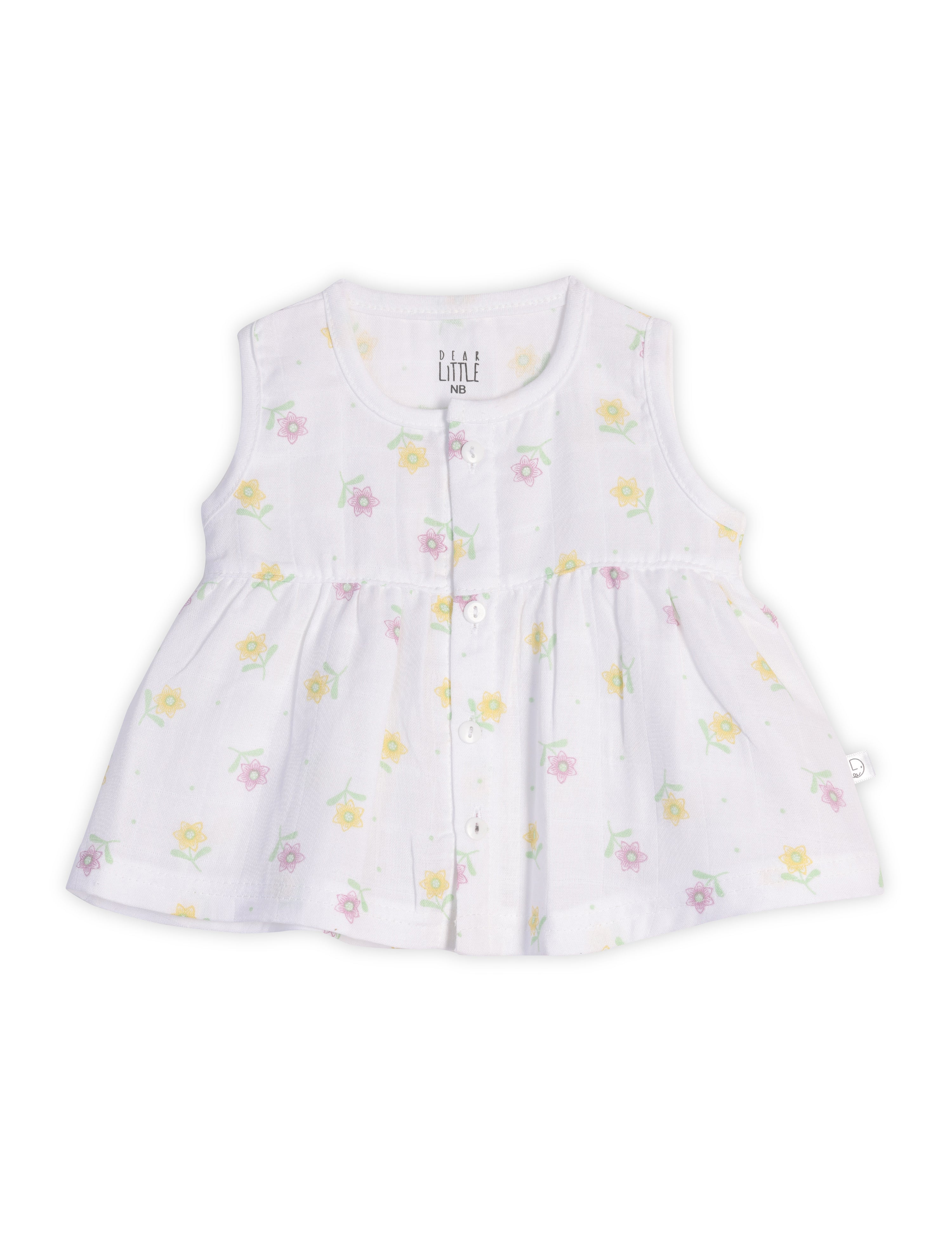 A sleeveless white baby frock with floral prints, made from muslin fabric, with a ruffled hemline.