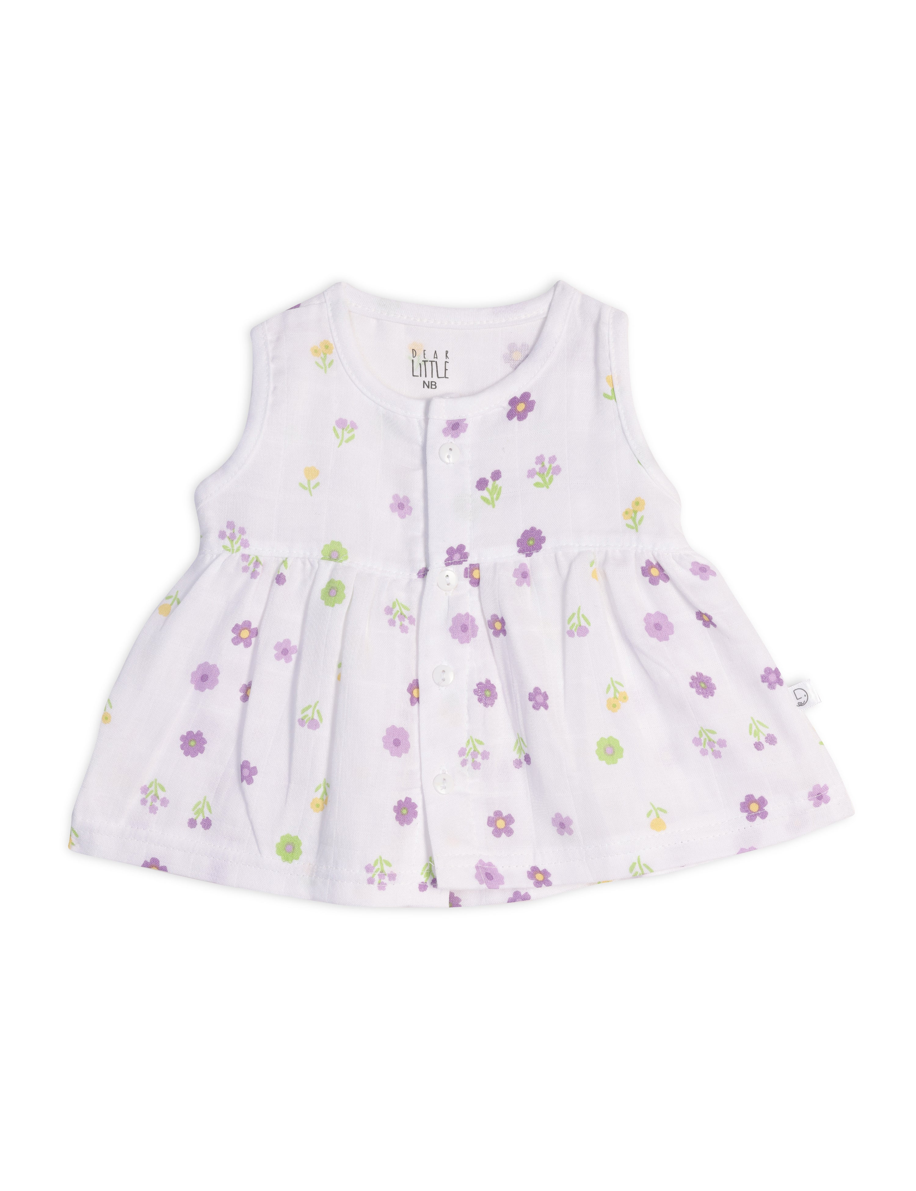 A sleeveless white baby frock with floral prints, made from muslin fabric.