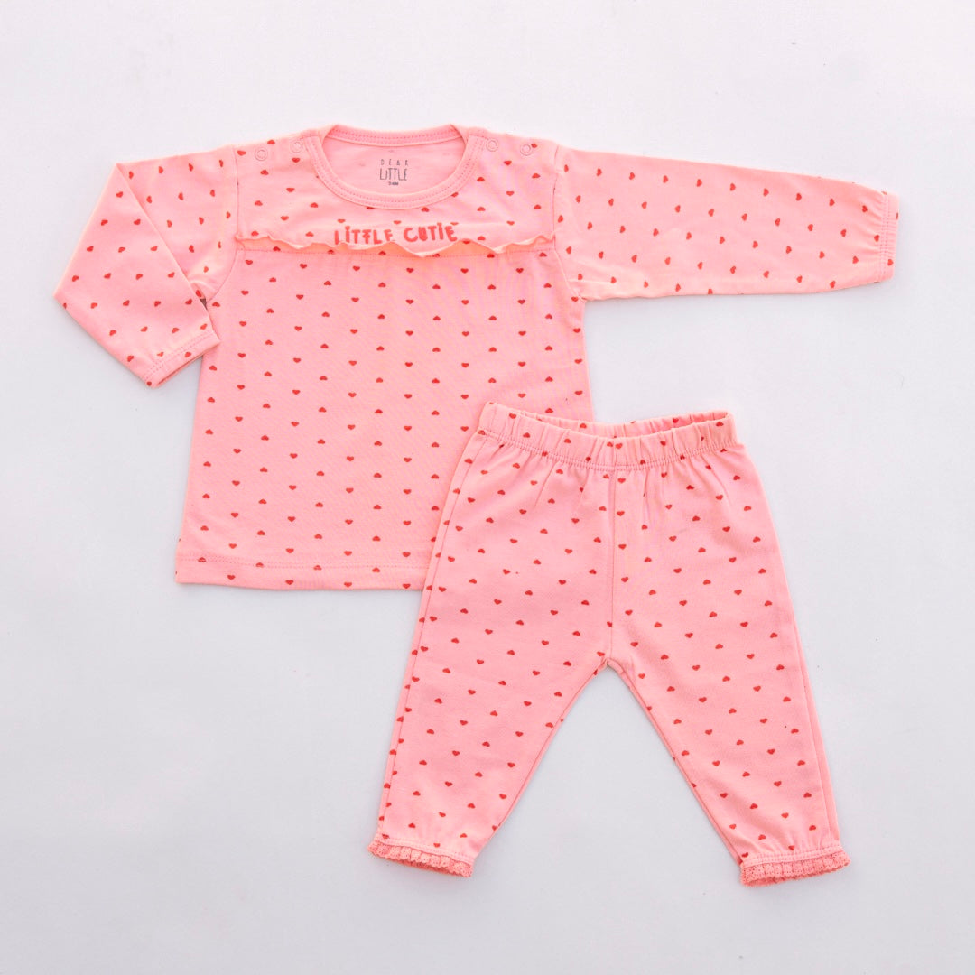 A set of children's clothing, with a long-sleeve top and leggings, in peach color, featuring heart patterns and lace trim.