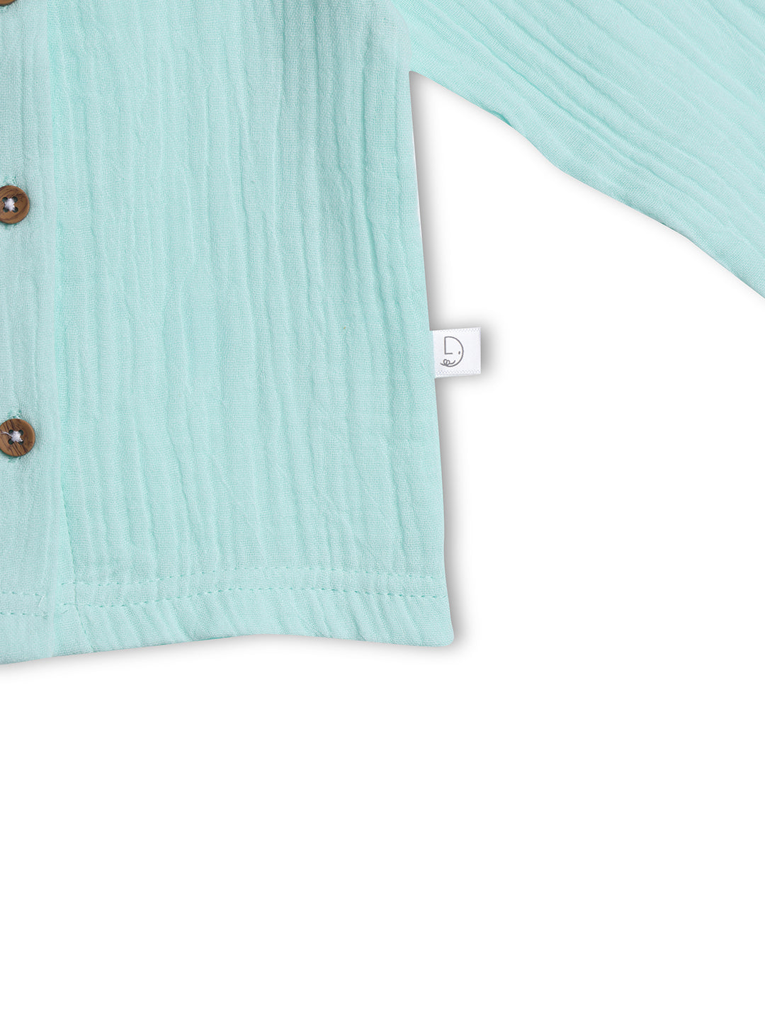 Close-up of a light blue textured fabric with brown buttons on a white background