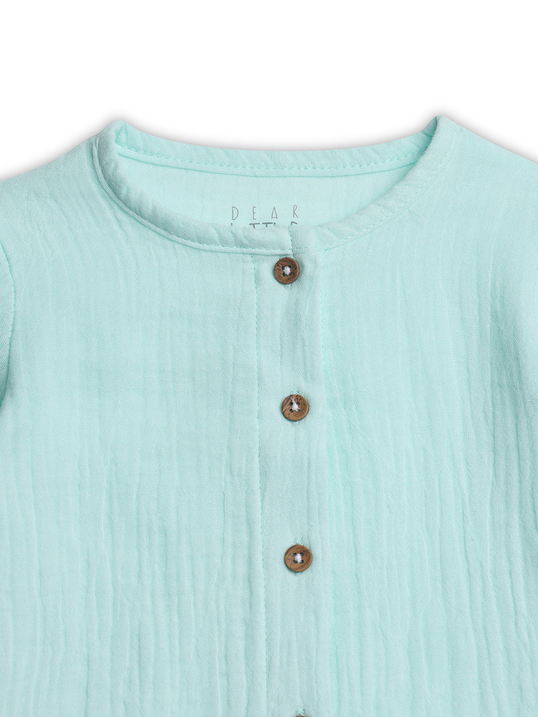 Close-up of a light blue textured shirt with buttons on a white background