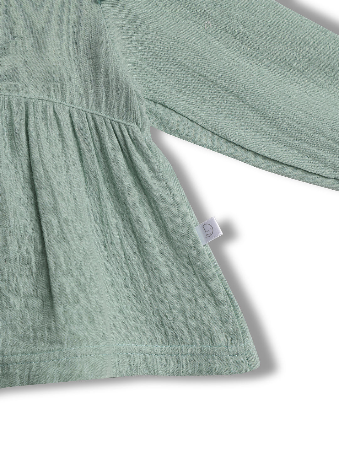 Close-up of a green fabric with a tag on a white background