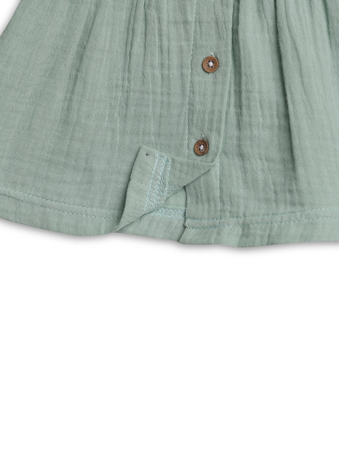 Close-up of a green textured shirt with buttons on a white background