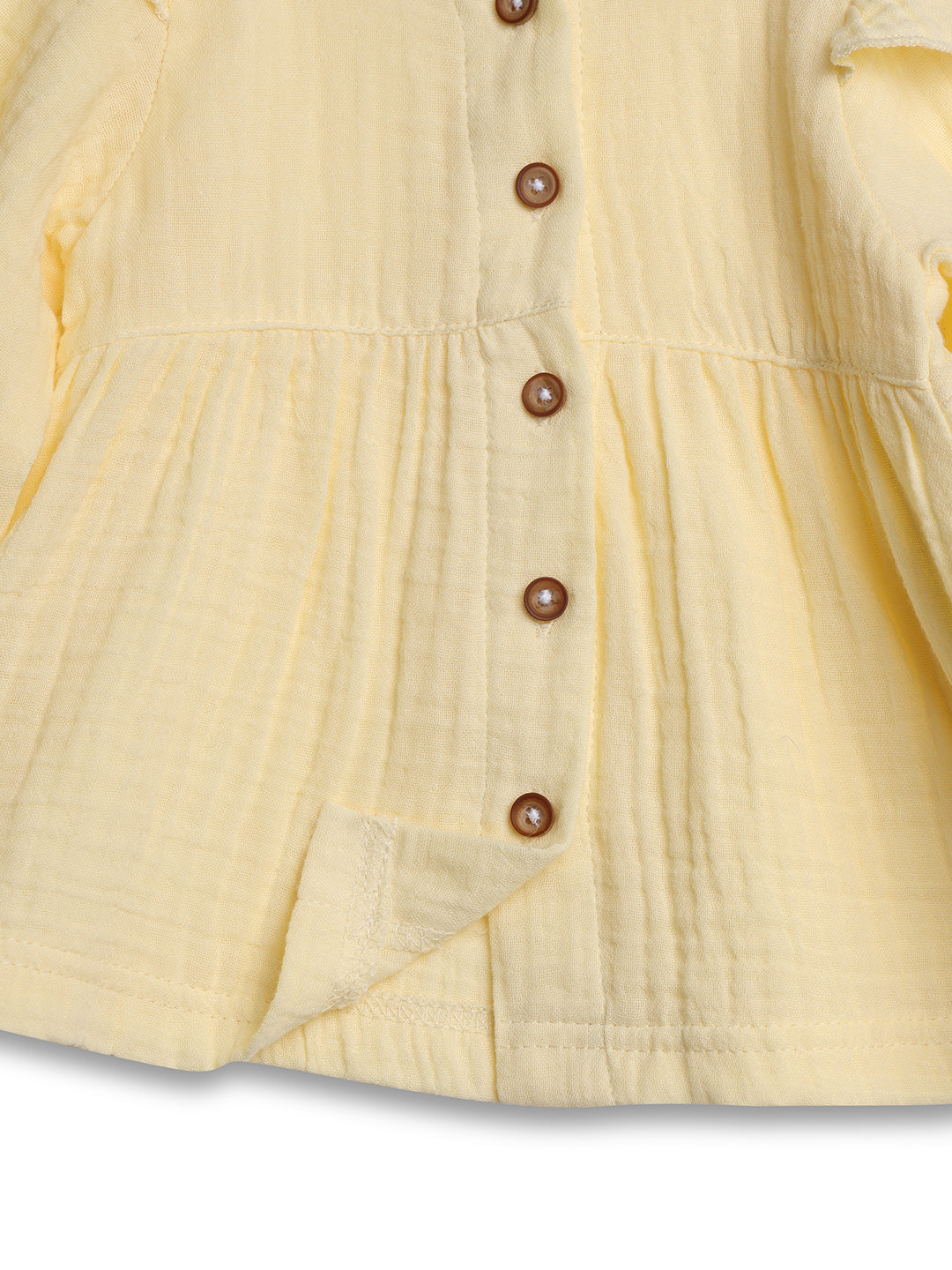 Close-up of a yellow dress with buttons on a white background