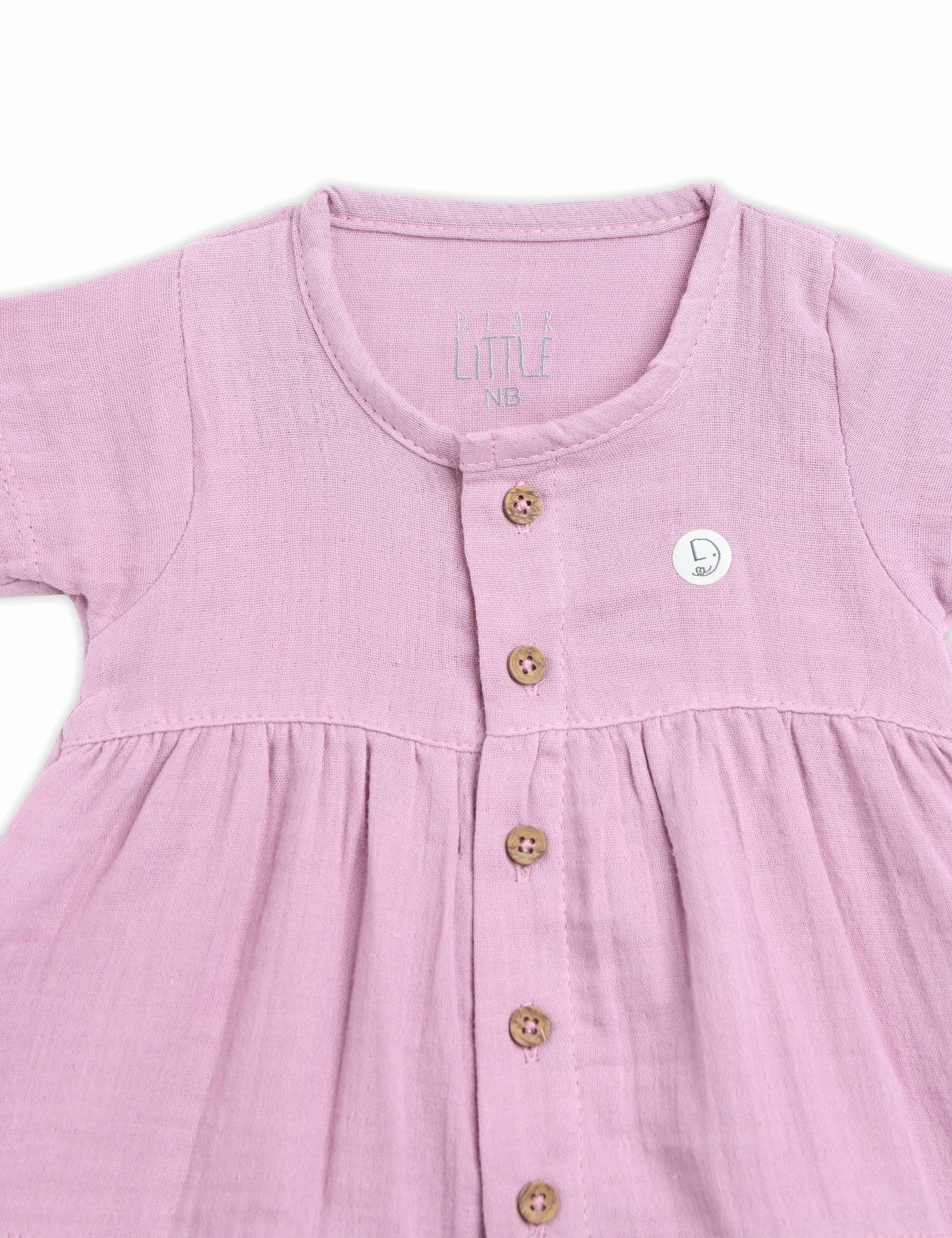 Pink baby dress with buttons on a white background