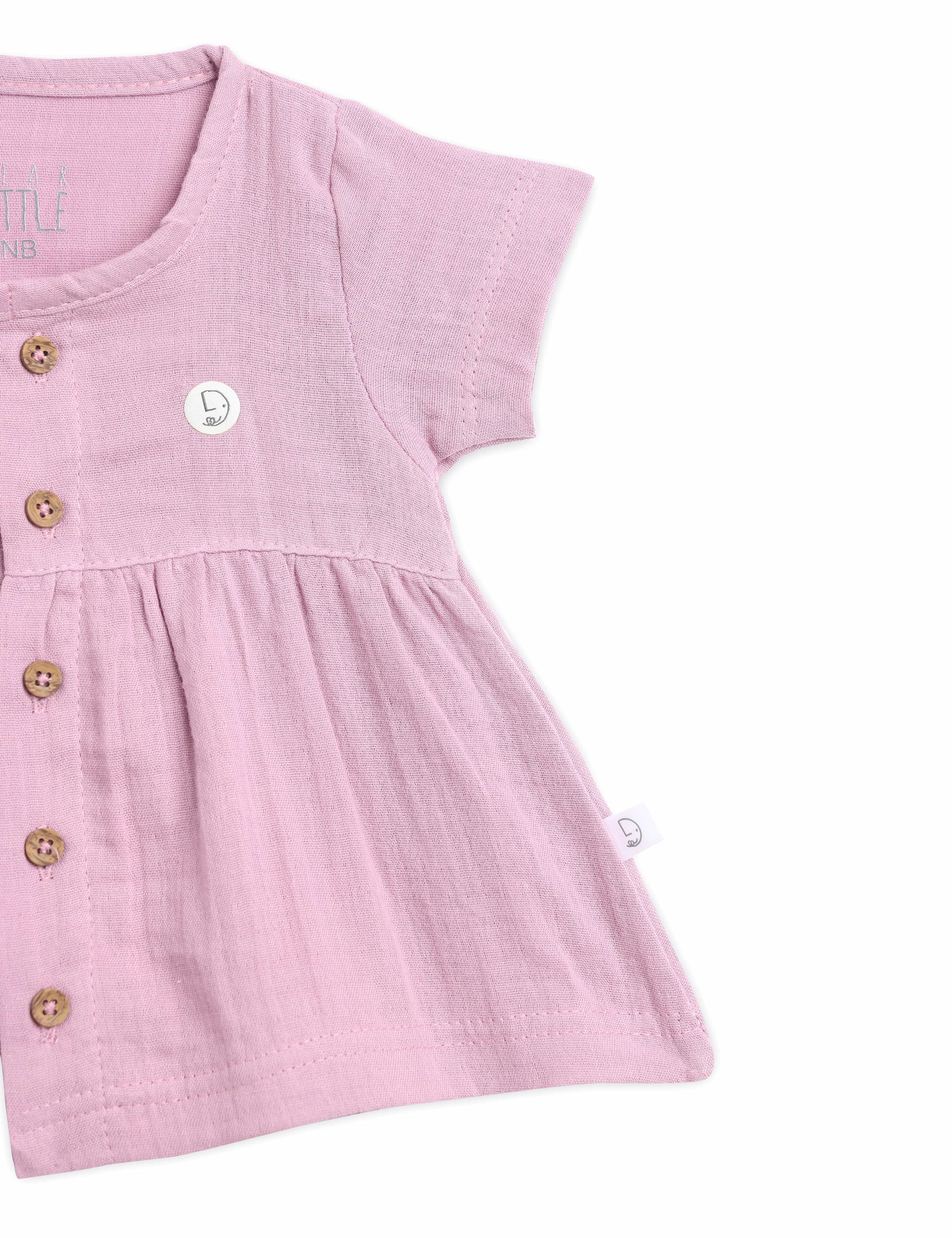 Pink baby dress with button details on a white background
