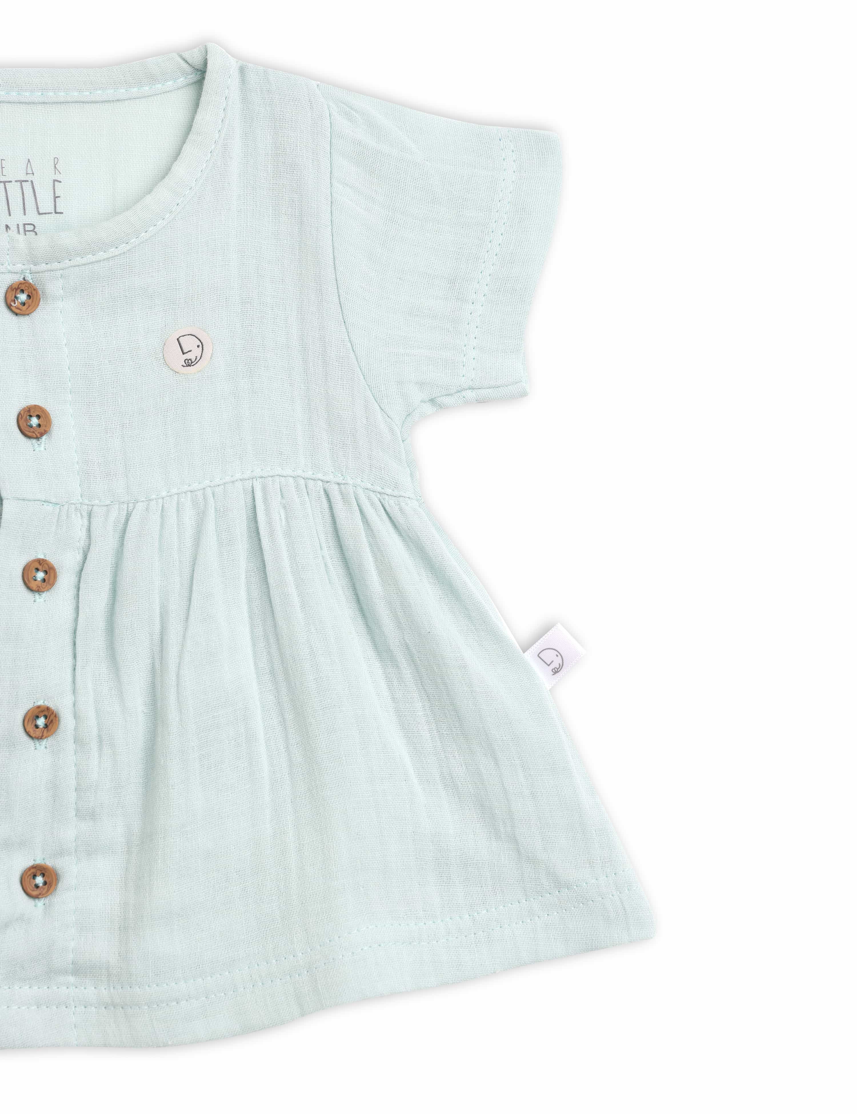 Light blue baby dress with buttons on a white background