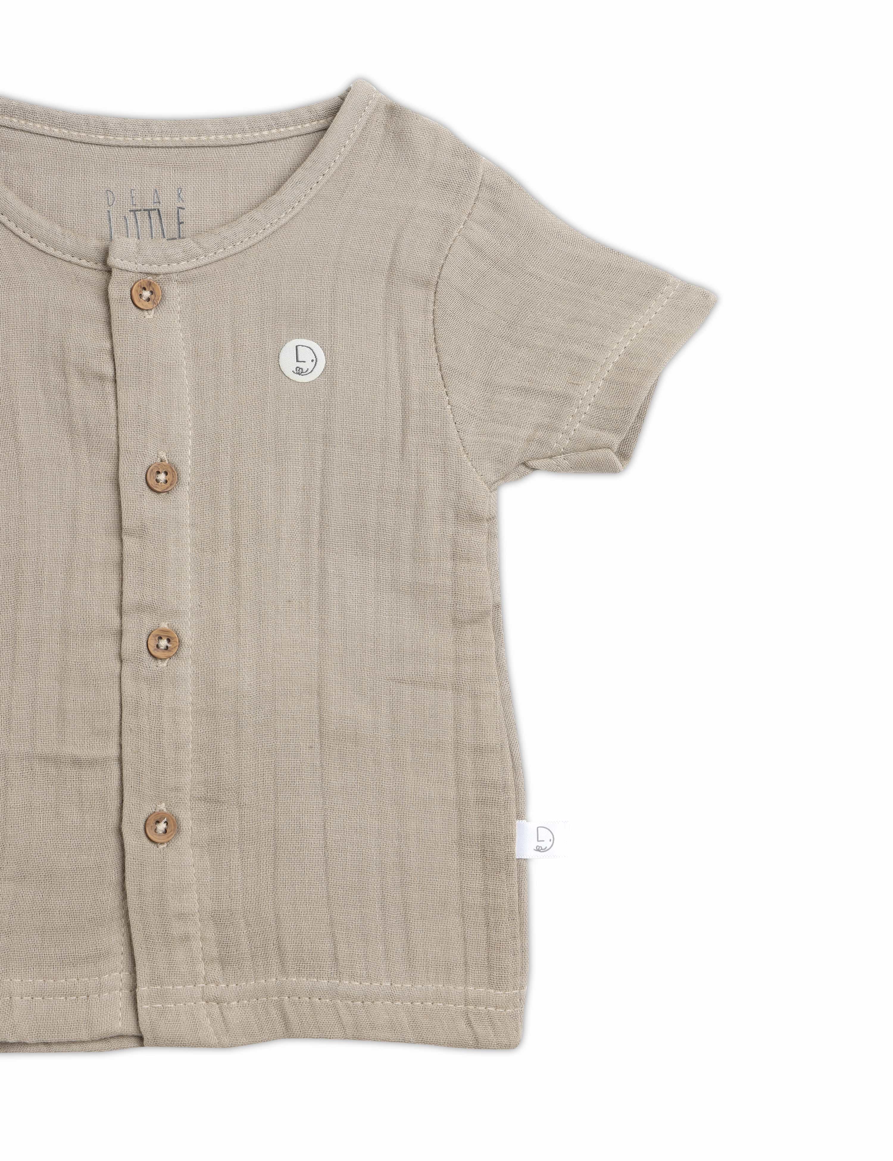 Beige baby shirt with buttons on a white background