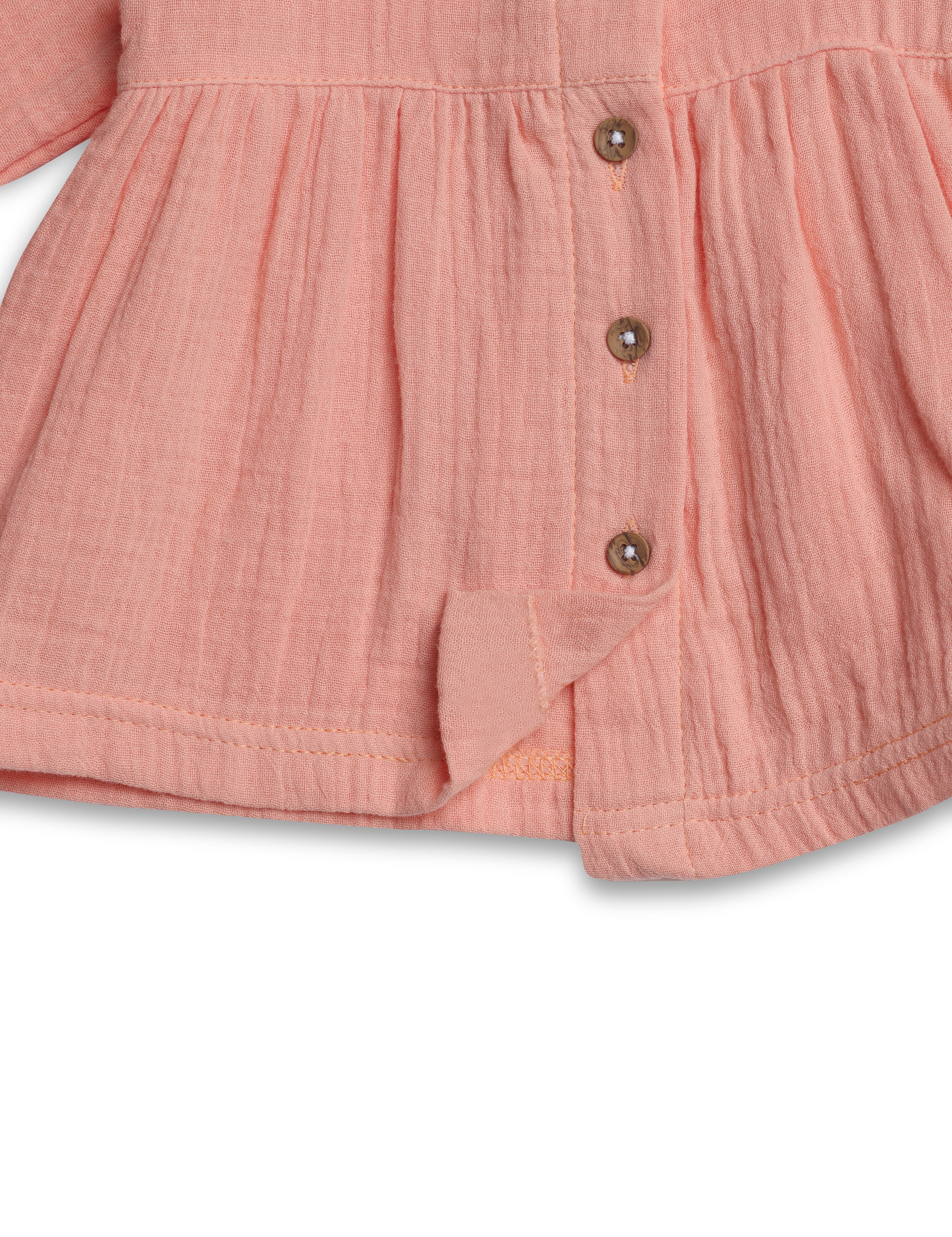 Close-up of a pink baby romper with buttons on a white background