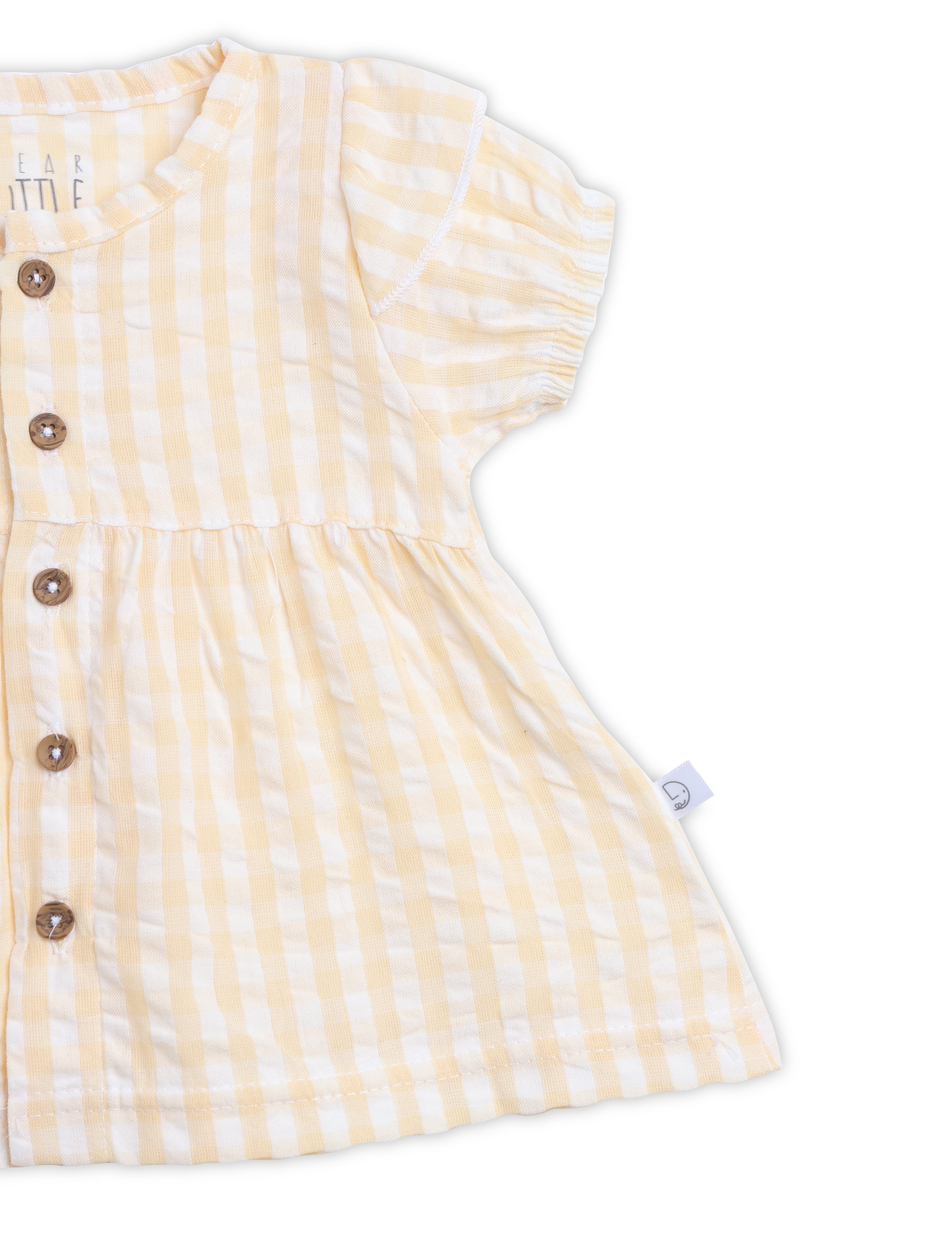 Yellow and white striped baby dress with buttons on a white background