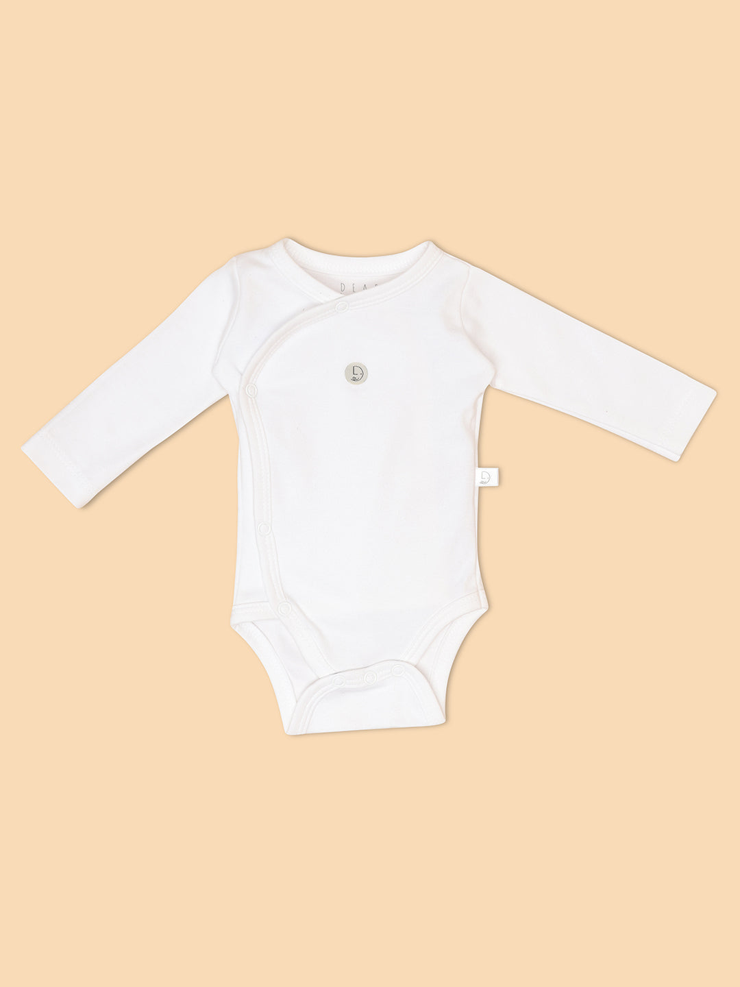 A white long-sleeved romper for a newborn baby displayed against a neutral background.