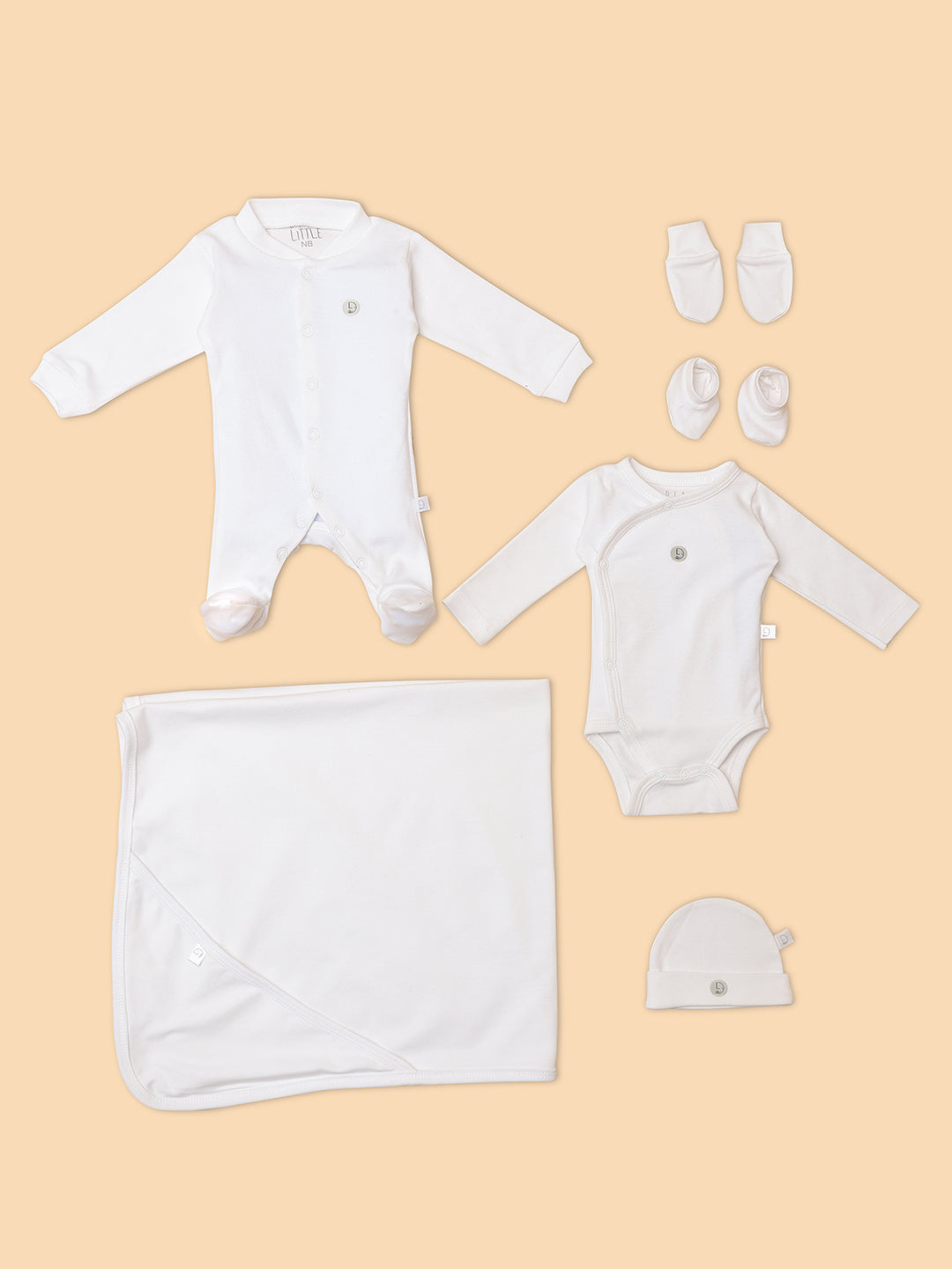 A collection of newborn baby items including a romper, sleepsuit, towel, cap, booties, and mittens.