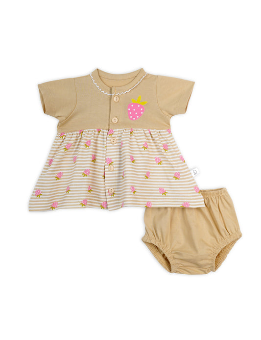 A beige colored frock with strawberry prints, consisting of a top with short sleeves and a skirt with bloomers. 